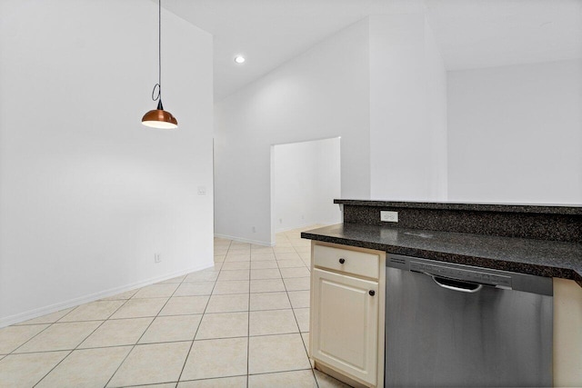 kitchen featuring cream cabinets, light tile patterned flooring, decorative light fixtures, stainless steel dishwasher, and dark stone counters