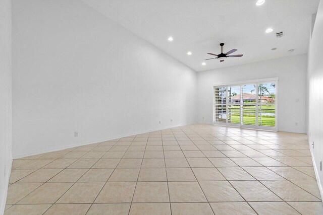 tiled empty room featuring ceiling fan and high vaulted ceiling