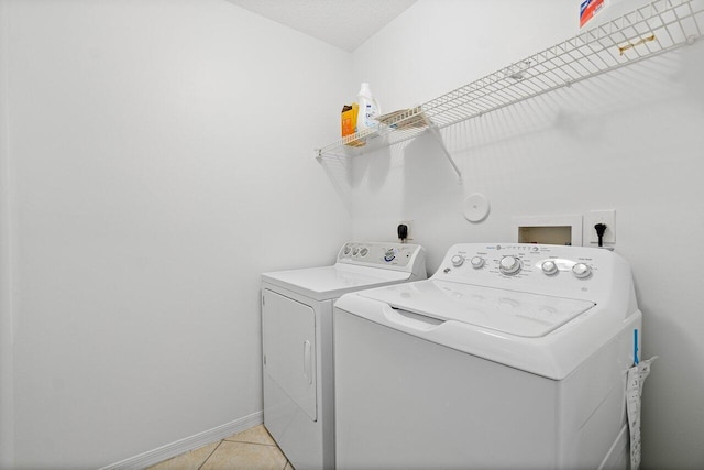 laundry room with washer and clothes dryer and light tile patterned flooring