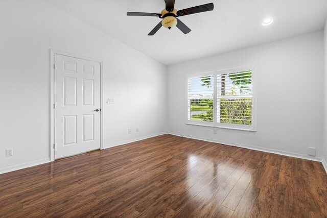 empty room with a textured ceiling, dark hardwood / wood-style flooring, ceiling fan, and lofted ceiling