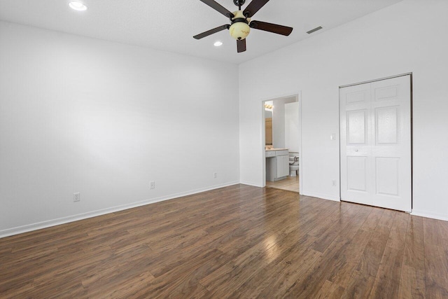 unfurnished bedroom with ensuite bath, ceiling fan, and dark wood-type flooring