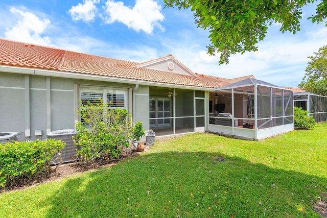 rear view of house featuring central AC unit and a yard