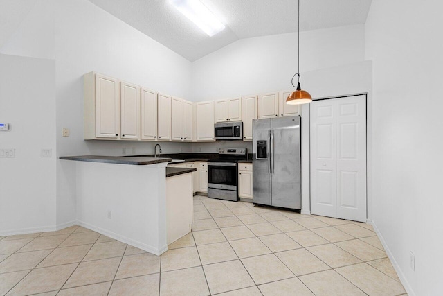 kitchen featuring sink, hanging light fixtures, kitchen peninsula, light tile patterned flooring, and appliances with stainless steel finishes