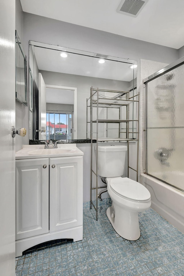 full bathroom featuring toilet, vanity, and shower / bath combination with glass door