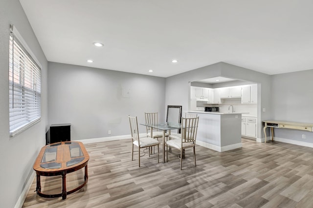 dining area with sink and light hardwood / wood-style flooring