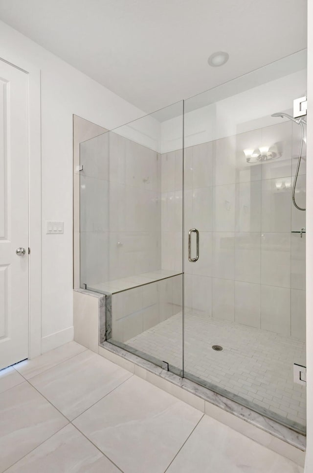 bathroom with walk in shower and tile patterned flooring