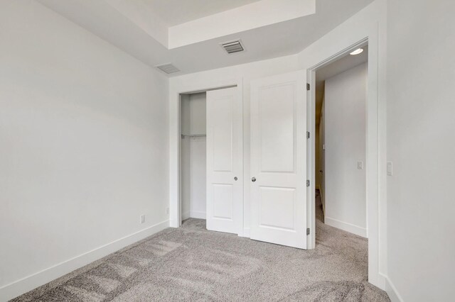 unfurnished bedroom featuring carpet flooring and a closet