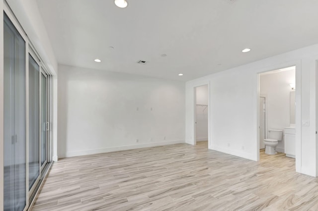 unfurnished bedroom with connected bathroom and light hardwood / wood-style flooring