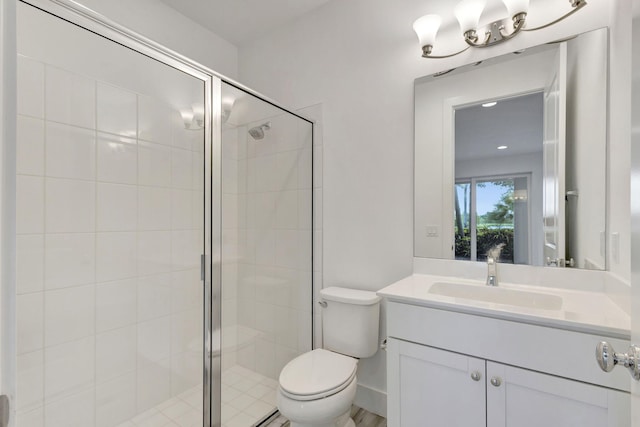 bathroom with a shower with shower door, vanity, and toilet