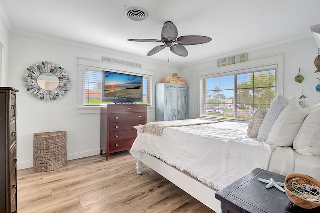 bedroom featuring light hardwood / wood-style flooring, ceiling fan, multiple windows, and crown molding