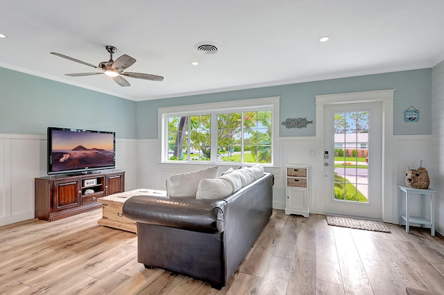 living room featuring ceiling fan, a wealth of natural light, crown molding, and light hardwood / wood-style flooring