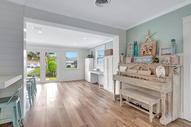 interior space featuring light wood-type flooring, crown molding, and visible vents