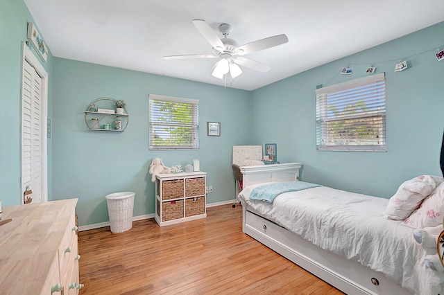 bedroom with baseboards, a closet, light wood-style flooring, and ceiling fan