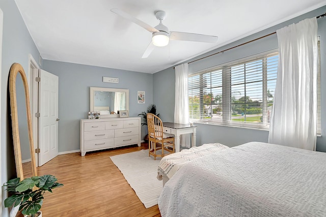 bedroom featuring light wood finished floors, baseboards, and ceiling fan