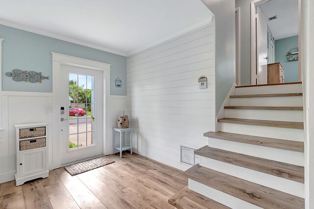 doorway featuring light hardwood / wood-style flooring and ornamental molding