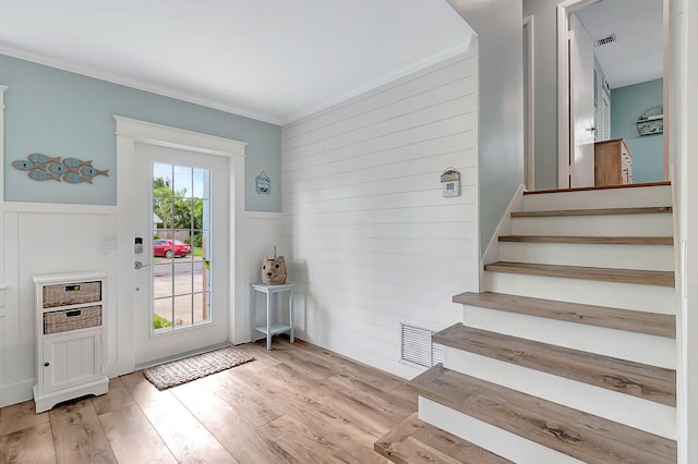 doorway to outside with visible vents, crown molding, stairs, and wood finished floors