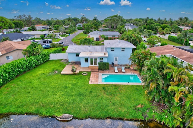 outdoor pool featuring a lawn, a fenced backyard, french doors, and a residential view