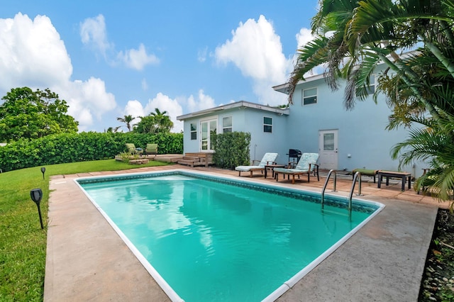 view of swimming pool featuring a fenced in pool, a yard, and a patio area