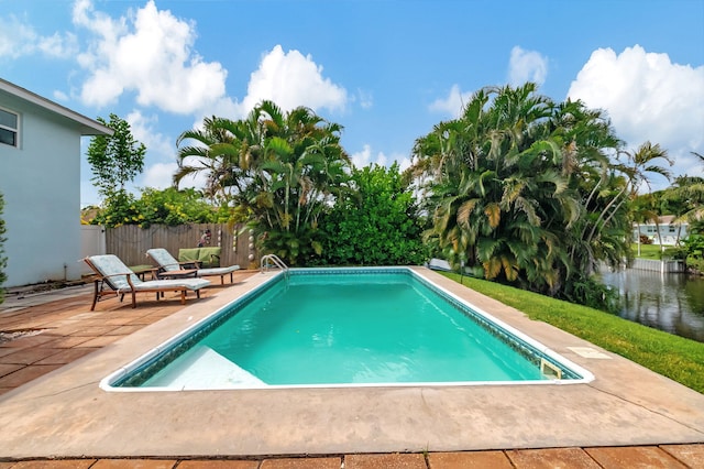 view of pool featuring a water view, fence, a fenced in pool, and a patio area