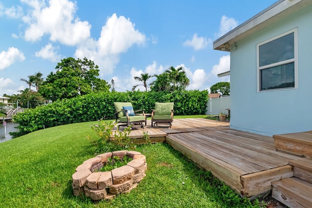 view of yard featuring fence, an outdoor fire pit, and a deck