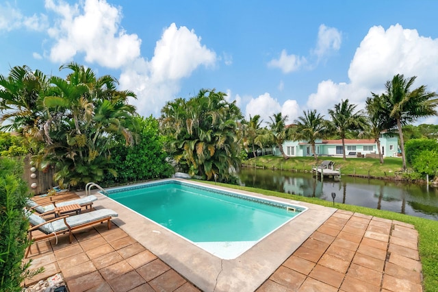 outdoor pool with a water view and a patio area