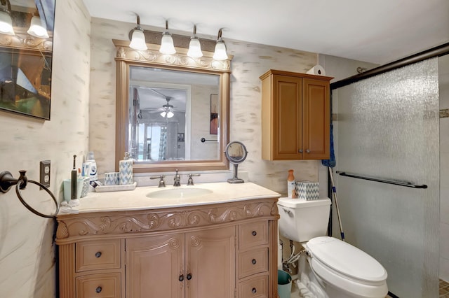 bathroom featuring toilet, vanity, ceiling fan, and walk in shower