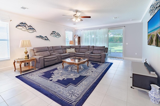 tiled living area with baseboards, visible vents, and a wealth of natural light