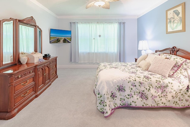 bedroom featuring baseboards, crown molding, light colored carpet, and ceiling fan