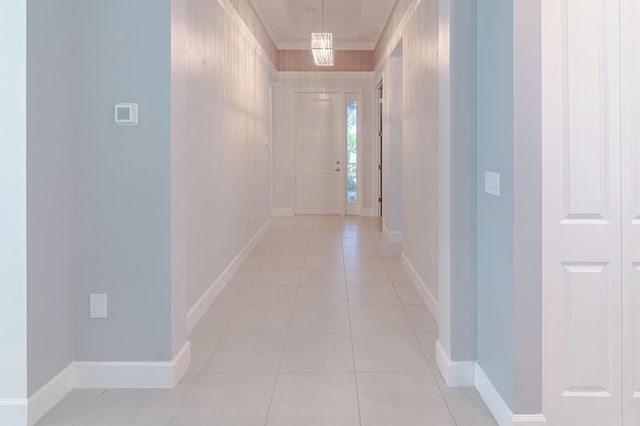 hall featuring light tile patterned floors and baseboards