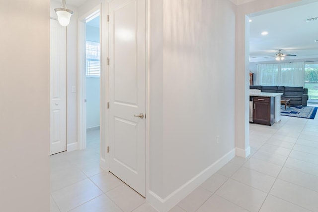 hallway with light tile patterned floors, visible vents, baseboards, and recessed lighting