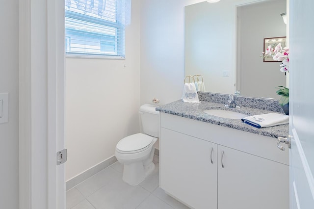 bathroom with toilet, tile patterned floors, baseboards, and vanity