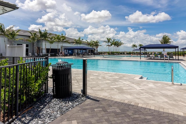 community pool featuring a patio area, fence, and a gazebo