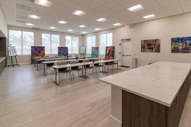 interior space with a drop ceiling and baseboards