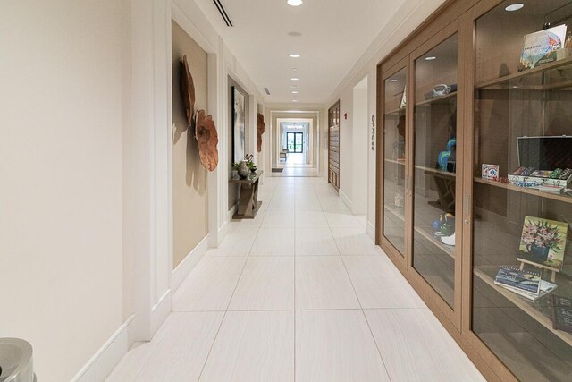 hallway with light tile patterned floors, visible vents, baseboards, and recessed lighting