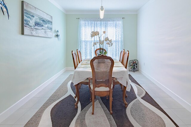 dining room with crown molding, baseboards, and light tile patterned floors