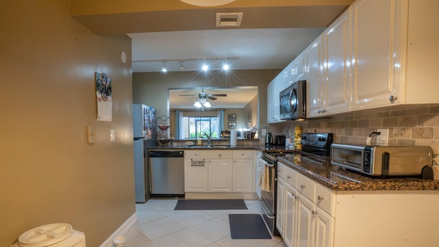 kitchen featuring ceiling fan, white cabinets, light tile patterned flooring, tasteful backsplash, and stainless steel appliances