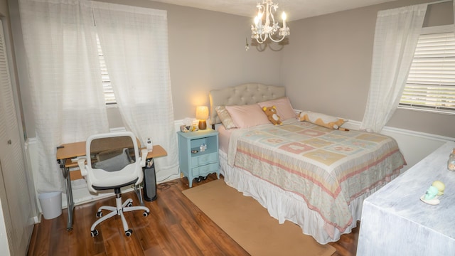 bedroom with an inviting chandelier and dark hardwood / wood-style flooring