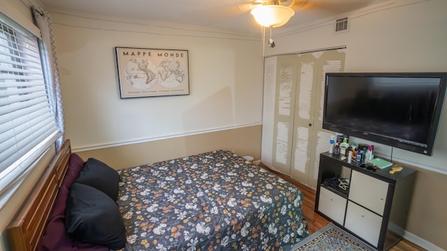 bedroom with ceiling fan, a closet, and wood-type flooring