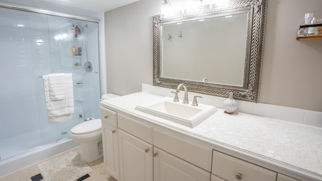 bathroom with tile patterned flooring, walk in shower, vanity, and toilet