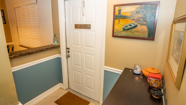 doorway to outside with light tile patterned floors