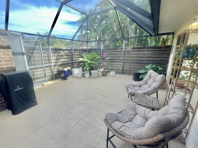 view of patio / terrace with glass enclosure and a grill