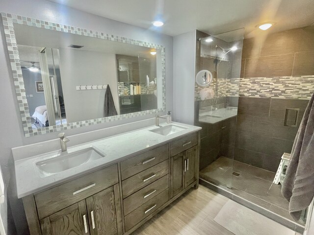 bathroom with vanity and a tile shower