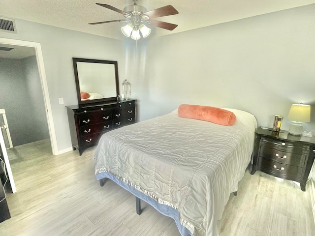 bedroom featuring a textured ceiling, ceiling fan, and light hardwood / wood-style floors