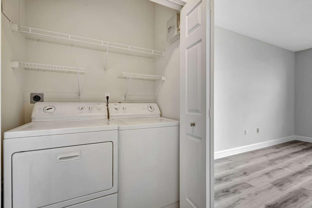 clothes washing area featuring independent washer and dryer and light hardwood / wood-style floors