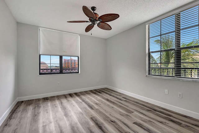 spare room featuring ceiling fan, wood-type flooring, and a textured ceiling