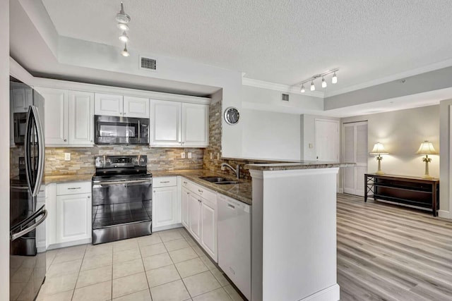 kitchen featuring tasteful backsplash, kitchen peninsula, white dishwasher, and range with electric cooktop