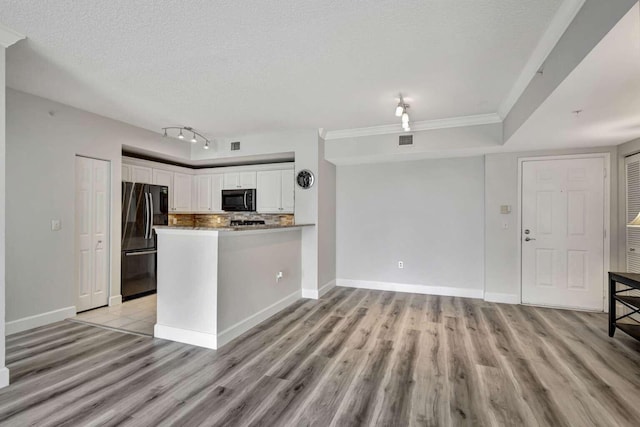 kitchen featuring a textured ceiling, white cabinetry, black appliances, and light hardwood / wood-style floors