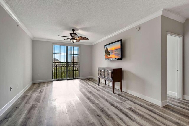 unfurnished room with a textured ceiling, ceiling fan, crown molding, and hardwood / wood-style flooring