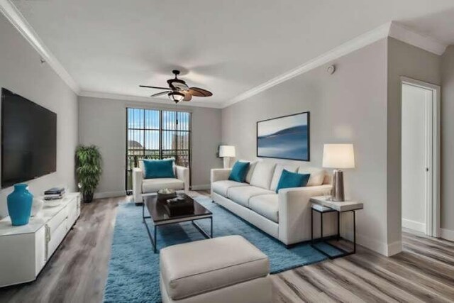 living room featuring hardwood / wood-style flooring, ornamental molding, and ceiling fan