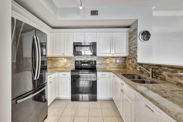 kitchen with sink, stainless steel appliances, decorative backsplash, and light stone counters